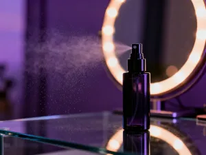 Elegancka butelka utrwalacza do makijażu Charlotte Tilbury na marmurowym blacie w luksusowym wnętrzu.